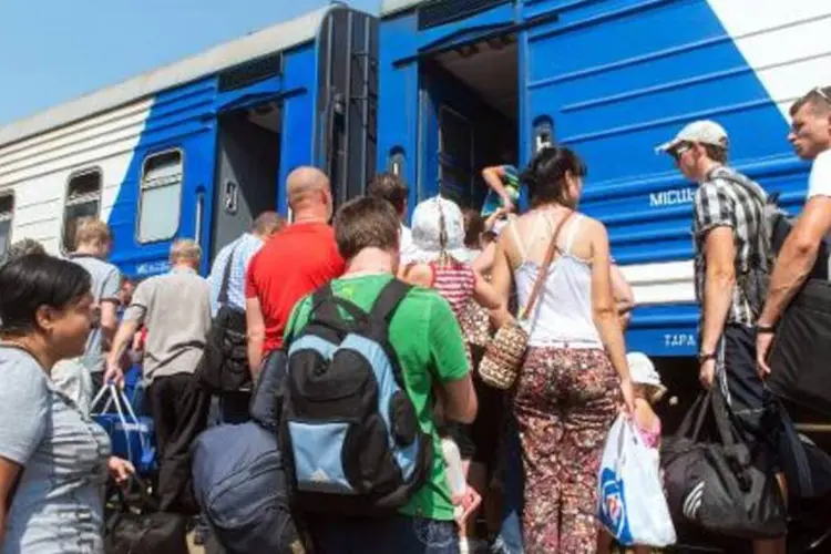 Pessoas embarcam em um trem para desabrigados, que deixa a pequena cidade ucraniana de Svatovo, na região de Lugansk (Sergey Bobok/AFP)