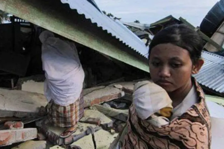 Uma jovem em meio às ruínas das casas destruídas por um terremoto em Blang Mancung, na Indonésia (03/07/2013) (.)