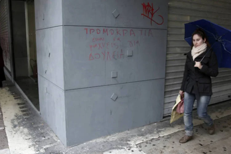 
	Mulher caminha em frente ao escrit&oacute;rio de desemprego em Atenas: taxa grega ainda &eacute; a mais alta da zona do euro
 (Yorgos Karahalis/Reuters)