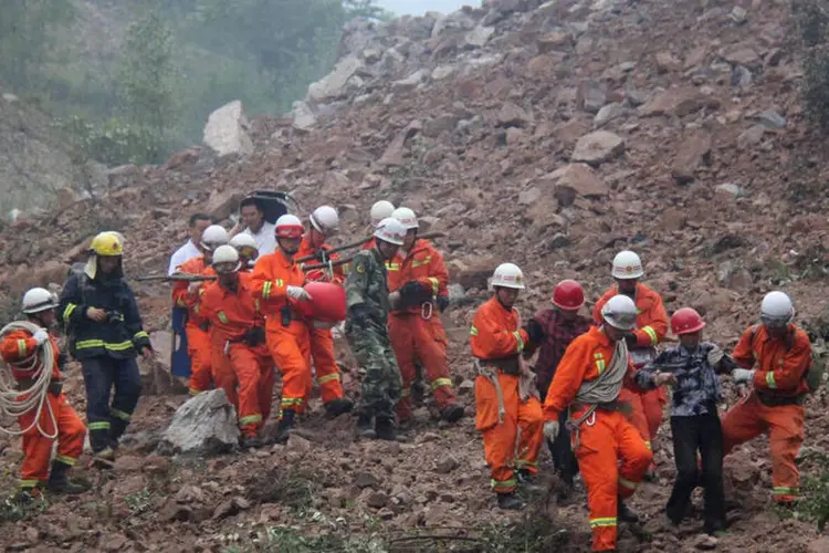 
	Equipe de resgate vasculha &aacute;rea do deslizamento: a popula&ccedil;&atilde;o local foi retirada do local onde trabalhava a mineradora Wuzhou
 (Reuters/ China Daily)