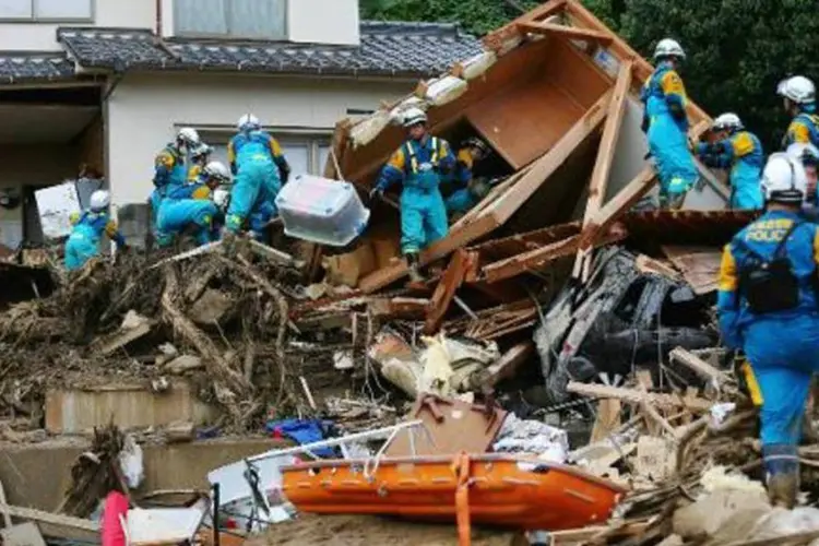 Policiais procuram desaparecidos em um deslizamento numa área residencial de Hiroshima (Jiji Press/AFP)