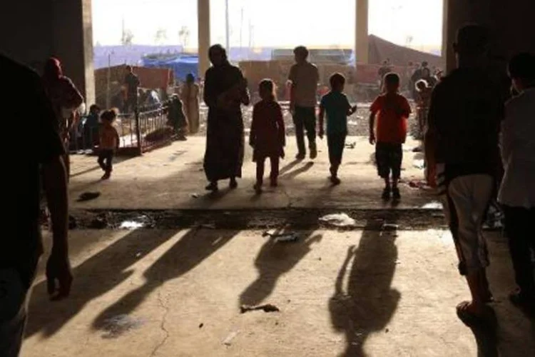 Iraquianos que fugiram de suas casas em Tal Afar são vistos em acampamento de Bahrka: ao todo, 600 mil já foram deslocados (Safin Hamed/AFP)