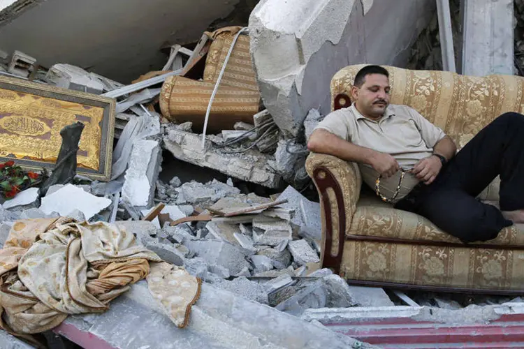 
	Homem sentado em destro&ccedil;os: para Gaza, grande desafio de reconstru&ccedil;&atilde;o vai come&ccedil;ar
 (Finbarr OReilly/Reuters)