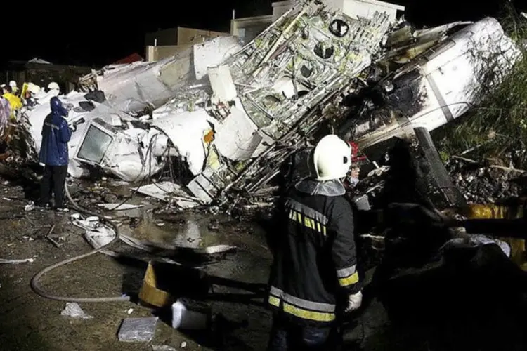 
	Bombeiros observam destro&ccedil;os do avi&atilde;o da TransAsia: avi&atilde;o levava 54 passageiros e 4 tripulantes a bordo
 (Wong Yao-wen/Reuters)