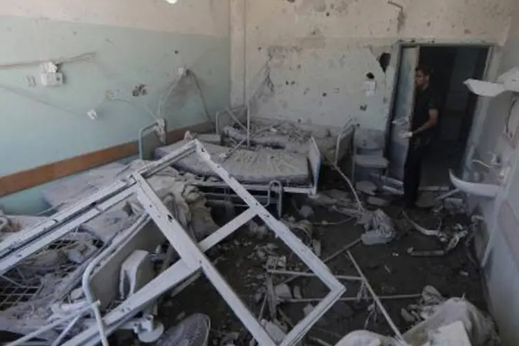 Palestino observa destruição causada por ataque aéreo israelense em hospital (Mohammed Abed/AFP)
