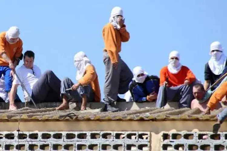 Detentos mantêm um refém no teto da Penitenciária de Cascavel, no Paraná (Marcelino Duarte/AFP)