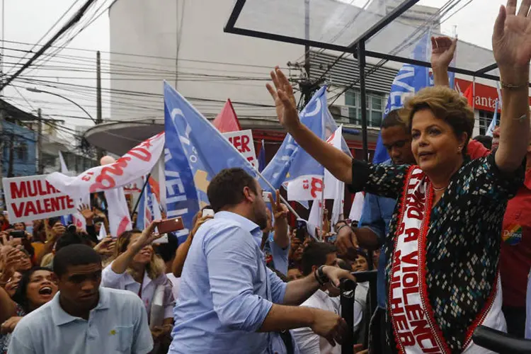 
	Presidente Dilma Rousseff (PT) acena para eleitores durante um com&iacute;cio em Duque de Caxias, perto do Rio de Janeiro
 (Ricardo Moraes/Reuters)