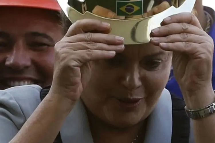 
	Dilma Rousseff usa capacete com seu nome, dado por trabalhadores da Arena Corinthians, um dos est&aacute;dios da Copa do Mundo
 (Nacho Doce/Reuters)