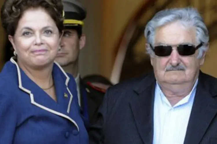 O presidente uruguaio ao lado da presidente brasileira, Dilma Rousseff: em contrapartida, Mujica reiterou que o Uruguai "tem que pegar uma carona com o Brasil" (Daniel Caselli/AFP)