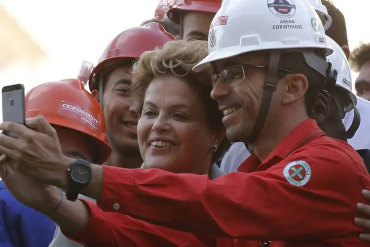 Trabalhadores tiram selfies com Dilma Rousseff durante visita da presidente no Itaquerão, zona leste de São Paulo (Nacho Doce/Reuters)