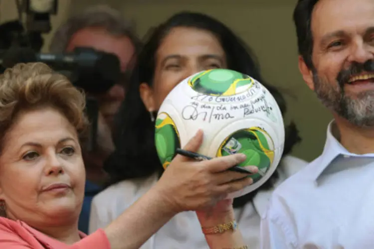 Presidente Dilma Rousseff mostra seu autógrafo em uma bola de futebol durante a inauguração do estádio Mané Garrincha, em Brasília (REUTERS/Ueslei Marcelino)