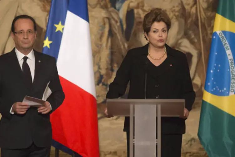 Presidente francês, François Hollande (E), ouve discurso da presidente Dilma Rousseff durante jantar no Palácio do Eliseu, em Paris (Michel Euler/Reuters)