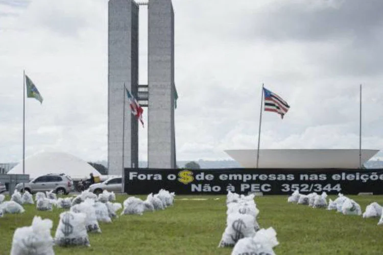 
	Sacos de &quot;dinheiro&quot; colocados em frente ao Congresso Nacional lembram o financiamento privado de campanhas; a a&ccedil;&atilde;o faz parte da Semana Nacional de Mobiliza&ccedil;&atilde;o pela Reforma Pol&iacute;tica
 (Marcelo Camargo)