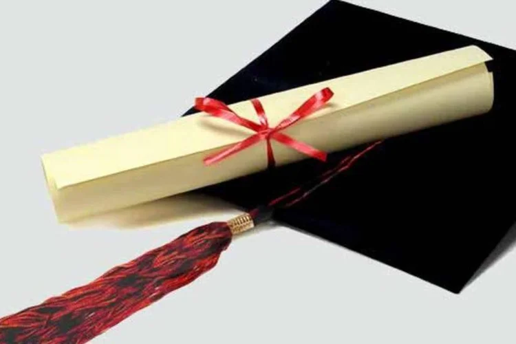 Diploma e chapéu sobre fundo cinza