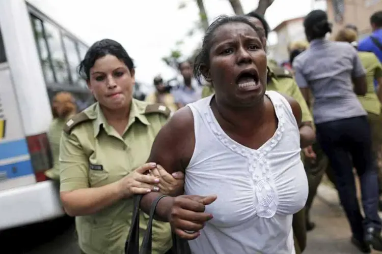 
	Policial prende militante em protesto do movimento dissidente Damas de Branco, em Havana, horas antes do in&iacute;cio da visita de Obama
 (REUTERS/Ueslei Marcelino)