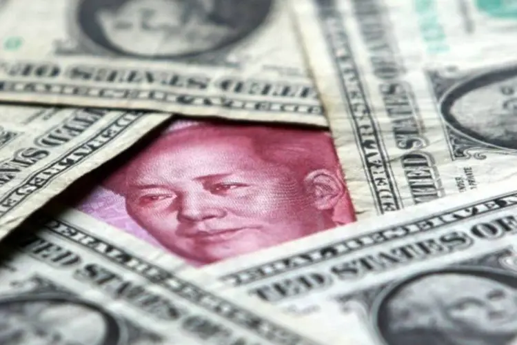 Notas de dólar e iuane (China Photos/Getty Images)