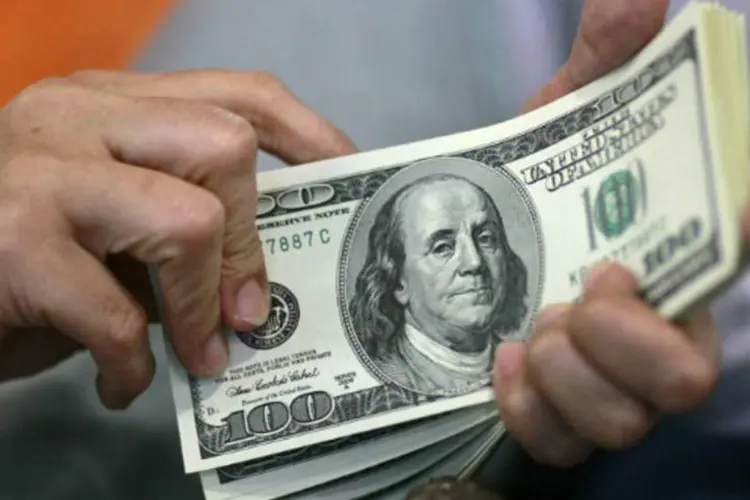 
	Pessoa segura notas de D&oacute;lar: ontem, o d&oacute;lar comercial fechou vendido a R$ 2,2575, com redu&ccedil;&atilde;o de 0,51%
 (REUTERS/Beawiharta)