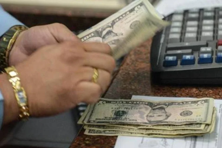
	Caixa conta d&oacute;lares em casa de c&acirc;mbio, em Caracas: &quot;No n&iacute;vel macroecon&ocirc;mico, conv&eacute;m &agrave; Am&eacute;rica Latina que o d&oacute;lar continue subindo porque torna suas exporta&ccedil;&otilde;es mais competitivas&quot;, afirmou o economista Jorge Gonz&aacute;lez Izquierdo
 (Federico Parra)