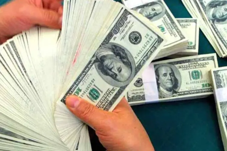 Homem contando dólares (Getty Images)