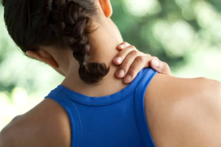 Mulher com dor no ombro: exercício consiste em fixar o 'elástico' de resistência no chão, segurá-lo com a mão e elevar os braços lateralmente para longe do corpo até formar um ângulo de 90 graus (Getty Images)