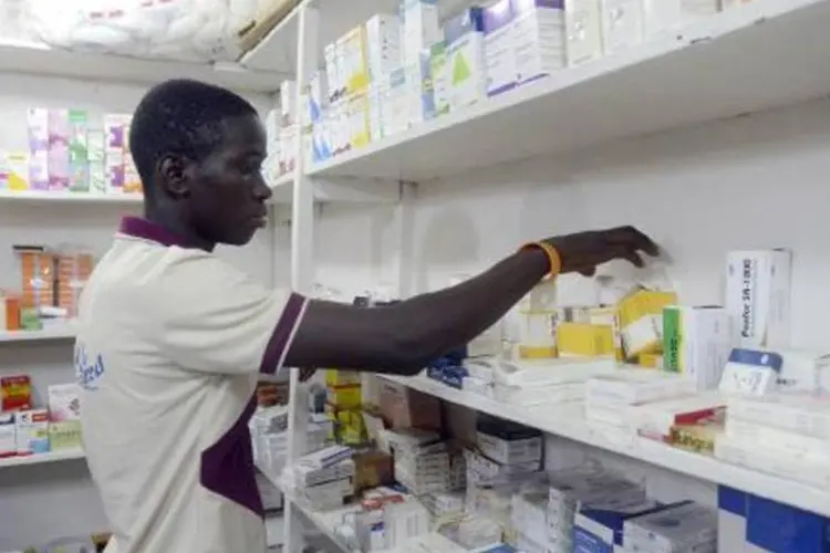 Um farmacêutico procura remédios em uma drogaria de Lagos, na Nigéria, em meio ao temor causado pela ameaça de epidemia do vírus ebola (Pius Utomi Ekpei/AFP)