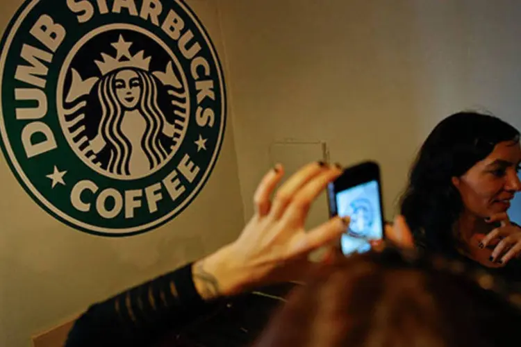 Consumidor tira foto do logo da Dumb Starbucks: a loja, uma paródia do Starbucks, se propagou rapidamente pelas redes sociais (Patrick T. Fallon/Bloomberg)