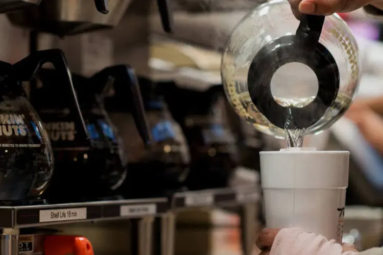 Funcionária do Dunkin’ Donuts serve um copo de ché em uma loja da rede em Manhattan, Nova York (Craig Warga/Bloomberg)