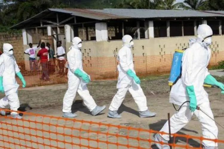 
	Na Liberia, trabalhadores da &aacute;rea de sa&uacute;de isolam &aacute;rea onde uma mulher morreu v&iacute;tima de Ebola
 (Ahmed Jallanzo/Agência Lusa/Agência Brasil)