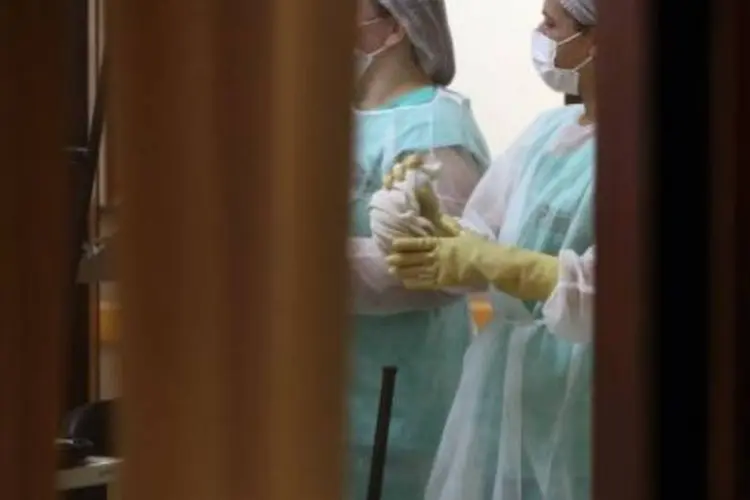 Enfermeiras aguardam no aeroporto de Cascavel, Paraná, a chegada de um homem da Guiné com suspeita de Ebola, transferido para o Rio de Janeiro (Fabio Conterno/AFP)