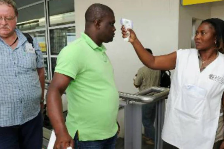 Médica controla temperatura de passageiros: febre hemorrágica matou 1.427 (AFP)