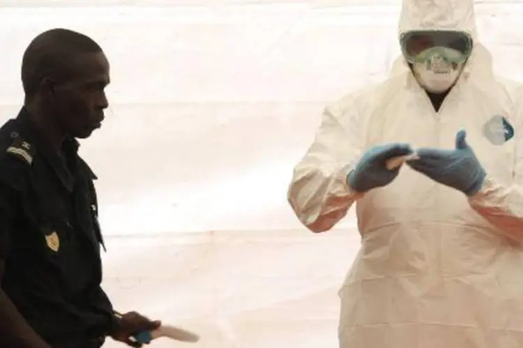 Agente sanitário mostra como se proteger do Ebola, no aeroporto de Dacar (Seyllou/AFP)