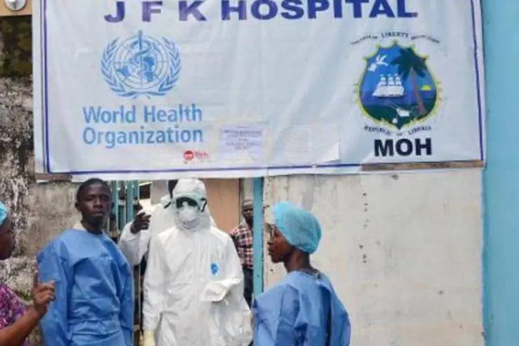 Agentes da saúde posam na entrada da Unidade de Tratamento do ebola, no Centro Médico John F. Kennedy, na capital liberiana Monróvia (Zoom Dosso/AFP)