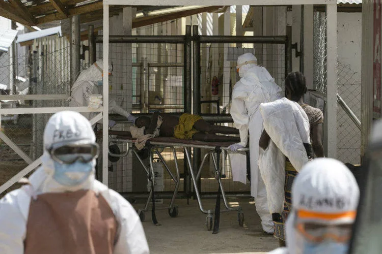 Agentes da saúde recebem novo paciente infectado pelo ebola, num centro de tratamento perto de Freetown, em Serra Leoa, em dezembro (Baz Ratner/Reuters)