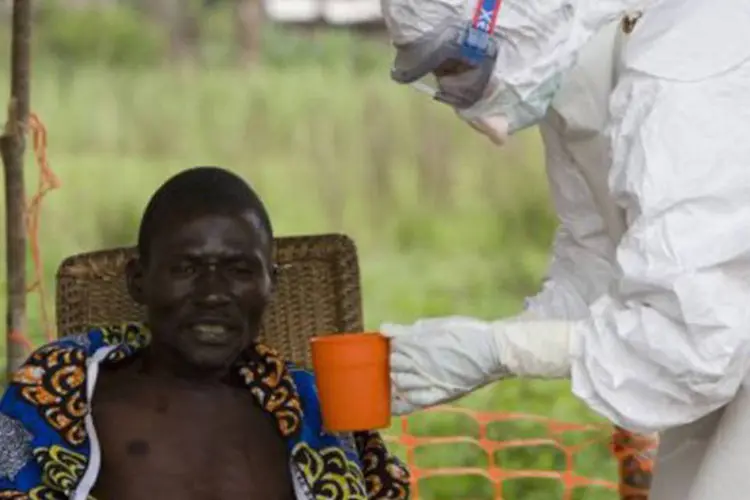 
	Membro dos M&eacute;dicos Sem Fronteiras trata um paciente sofrendo de ebola
 (Christopher Black/AFP)