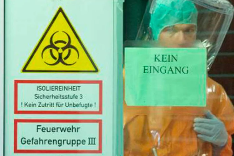 
	Funcion&aacute;rios do setor de sa&uacute;de aguardam paciente infectado por ebola no Hospital Universit&aacute;rio de Frankfurt
 (Boris Roessler/AFP)