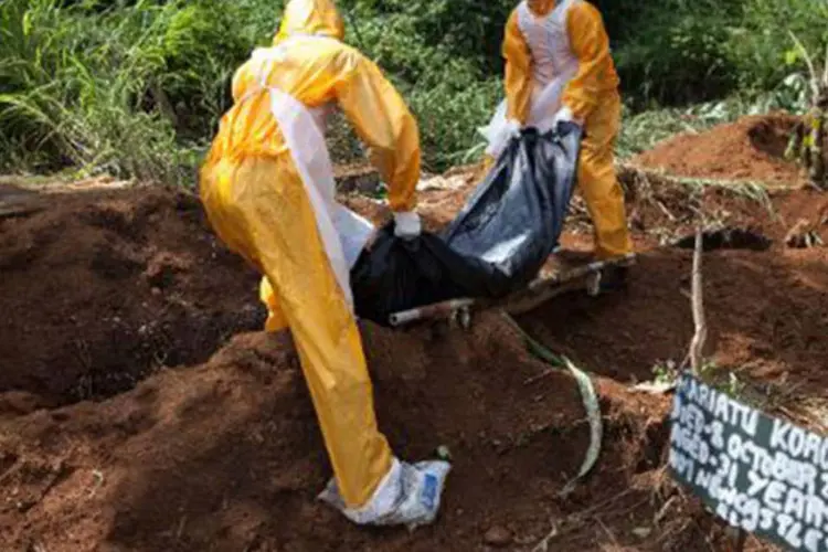 Equipe especializada no enterro de vítimas do vírus Ebola no cemitério Fing Tom, de Freetown, Serra Leoa
 (FLORIAN PLAUCHEUR/AFP)