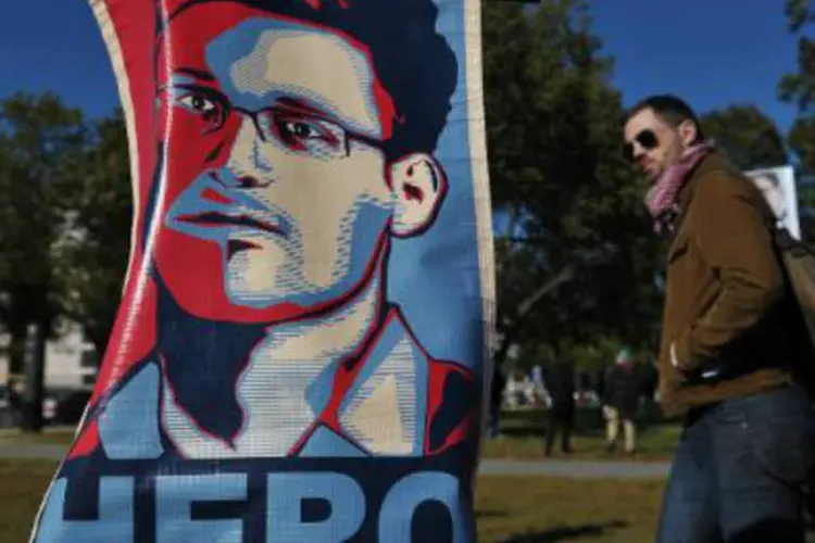 
	Cartaz chama Edward Snowden de her&oacute;i, em protesto contra a espionagem americana: advogada disse que seu asilo tempor&aacute;rio na R&uacute;ssia ir&aacute; expirar no fim de junho
 (Mandel Ngan/AFP)