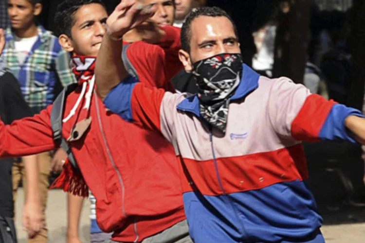 
	Manifestantes atiram pedras na tropa de choque durante um protesto que marca um ano de embates fatais na rua Mohamed Mahmoud, pr&oacute;ximo ao Minist&eacute;rio do Interior no Cairo
 (Mohamed Abd El Ghany/Reuters)