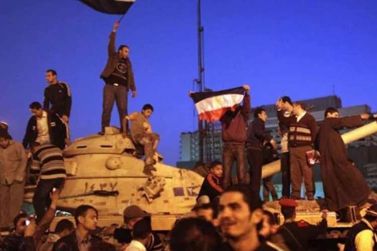 Ao receberem a notícia da renúncia, egípcios na praça Tahrir e em todo o Cairo agitaram bandeiras para comemorar (Getty Images)