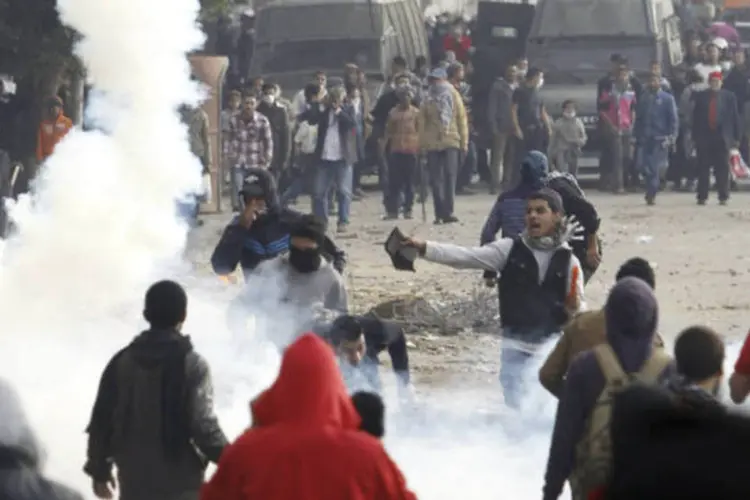 Manifestantes de oposição ao presidente egípcio Mohamed Mursi fogem de gás lacrimogêneo disparado pela polícia durante os confrontos no Cairo (REUTERS / Amr Abdallah Dalsh)