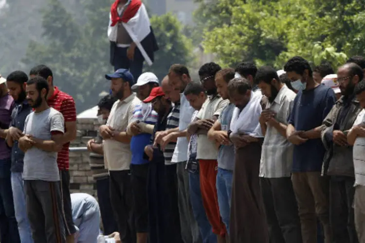 Membros da Irmandade Mulçumana e apoiadores do presidente deposto do Egito Mohamed Mursi rezam em frente ao quartel general da Guarda Republicana, no Cairo (Amr Abdallah Dalsh/Reuters)