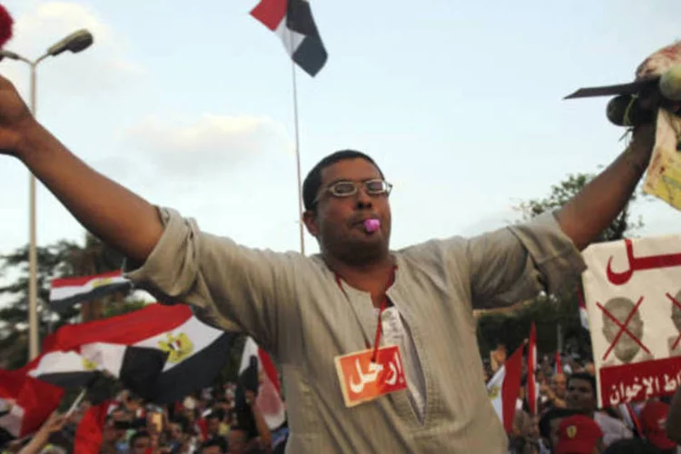Manifestante contra o presidente do Egito, Mohamed Mursi, segura um sapato e uma cabeça de cordeiro durante manifestação ao frente ao palácio presidencial no Cairo (REUTERS/Amr Abdallah Dalsh)