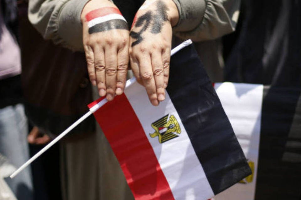 
	Manifestante contr&aacute;rio ao presidente Mohamed Mursi segura bandeira do Egito durante protresto no Cairo: Presid&ecirc;ncia do Conselho de Ministros confirmou o pedido de ren&uacute;ncia dos titulares das Rela&ccedil;&otilde;es Exteriores, Turismo, Telecomunica&ccedil;&otilde;es, Assuntos Parlamentares e Meio Ambiente
 (REUTERS/Suhaib Salem)