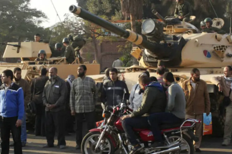 
	Apoiadores da Irmandade Mu&ccedil;ulmana ficam perto de tanques posicionados do lado de fora do pal&aacute;cio presidencial eg&iacute;pcio, no Cairo
 (REUTERS/Asmaa Waguih)