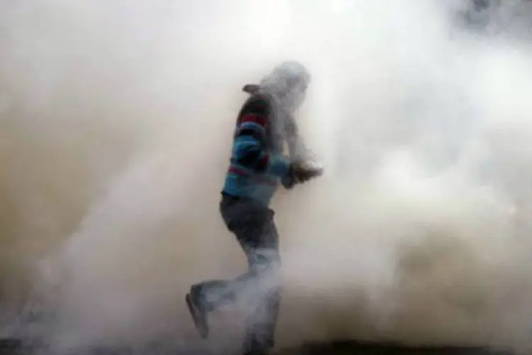 
	Manifestante joga cilindro de g&aacute;s lacrimog&ecirc;neo de volta na dire&ccedil;&atilde;o da pol&iacute;cia no Cairo
 (©AFP / Gianluigi Guercia)