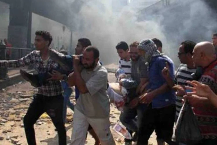 Simpatizantes da Irmandade Muçulmana carregam um manifestante ferido, no Cairo (©afp.com / Khaled Kamel)