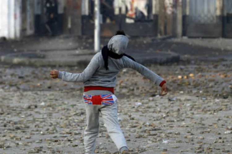 Estudante joga pedras: caso ocorreu na Universidade de Al-Azhar, quando policiais entraram no campus para enfrentar manifestantes que haviam ateado fogo ao edifício da faculdade de comércio (REUTERS/Amr Abdallah Dalsh)
