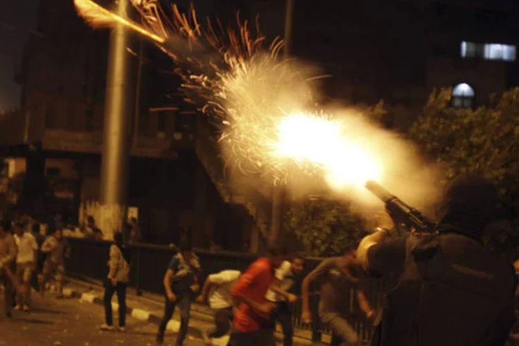 Um oficial da polícia dispara bombas de gás lacrimogêneo durante confrontos entre manifestantes anti-Mursi e os membros da Irmandade Muçulmana em uma rua que leva à Praça Tahrir ( REUTERS/Amr Abdallah Dalsh)