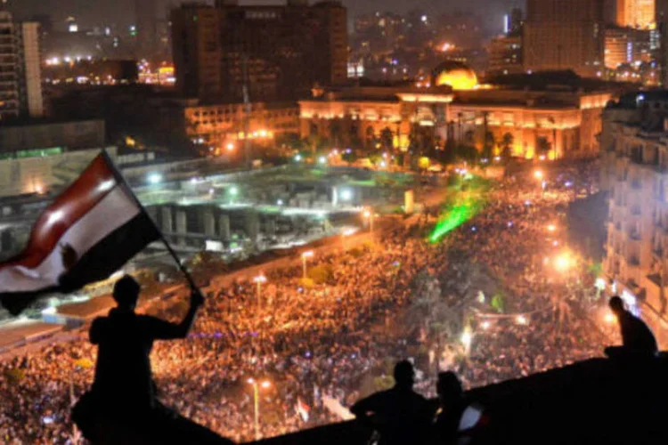
	Eg&iacute;pcios balan&ccedil;am a bandeira do pa&iacute;s no topo de um pr&eacute;dio com vista para a Pra&ccedil;a Tahir, ponto central dos manifestantes em julho de 2013 (7/7/2013)
 (MOHAMED EL-SHAHED/AFP/Getty Images)