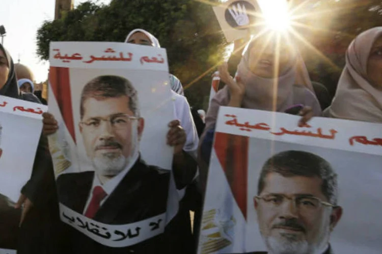 Apoiadores do presidente deposto Mursi seguram cartazes em protesto no Cairo,  neste domingo (REUTERS/Louafi Larbi)